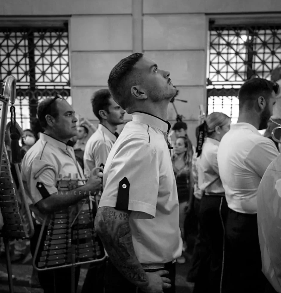 Javier Cebrero, de uniforme blanco, mira al paso durante una procesión